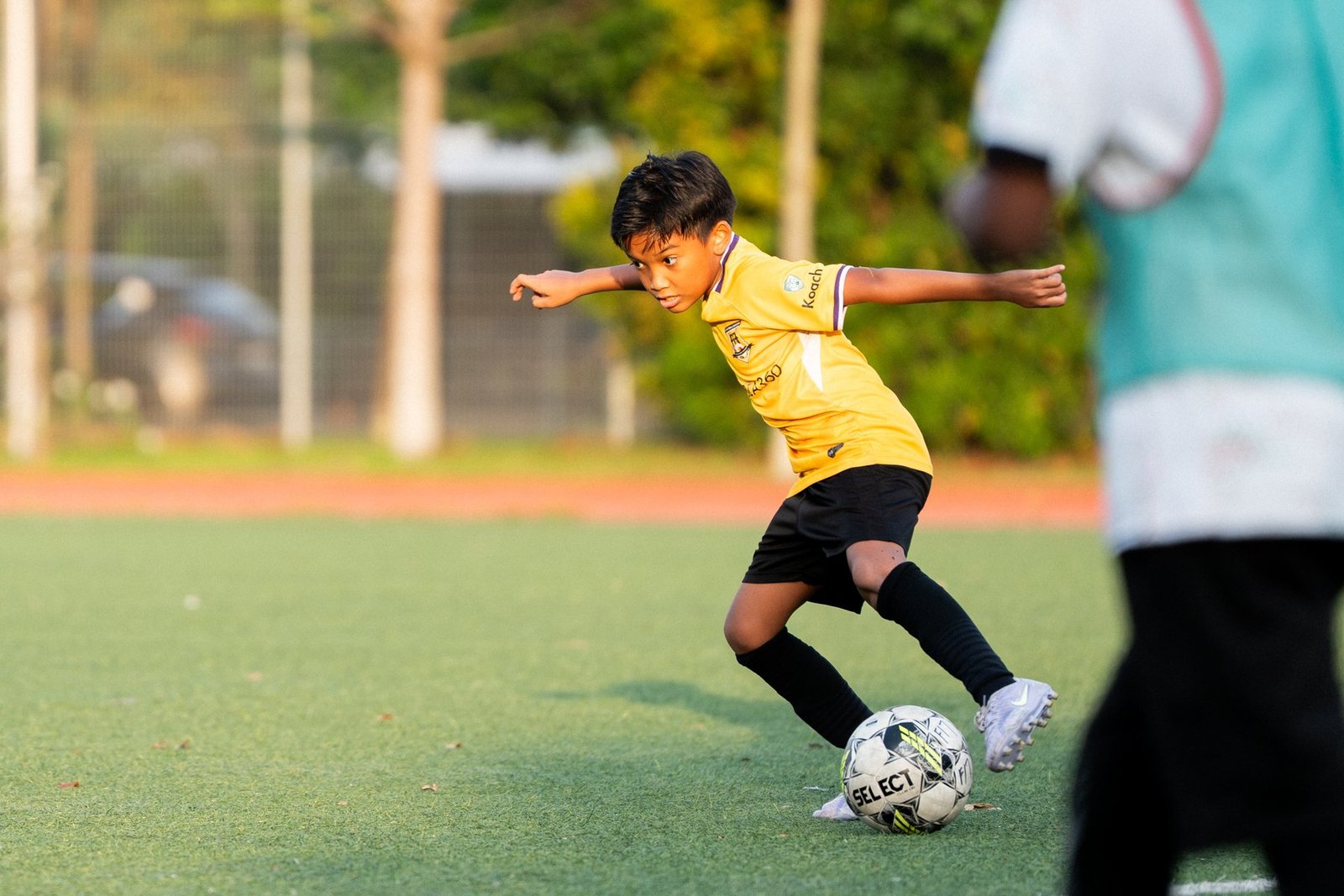 F17 player dribbling forward with intent during training